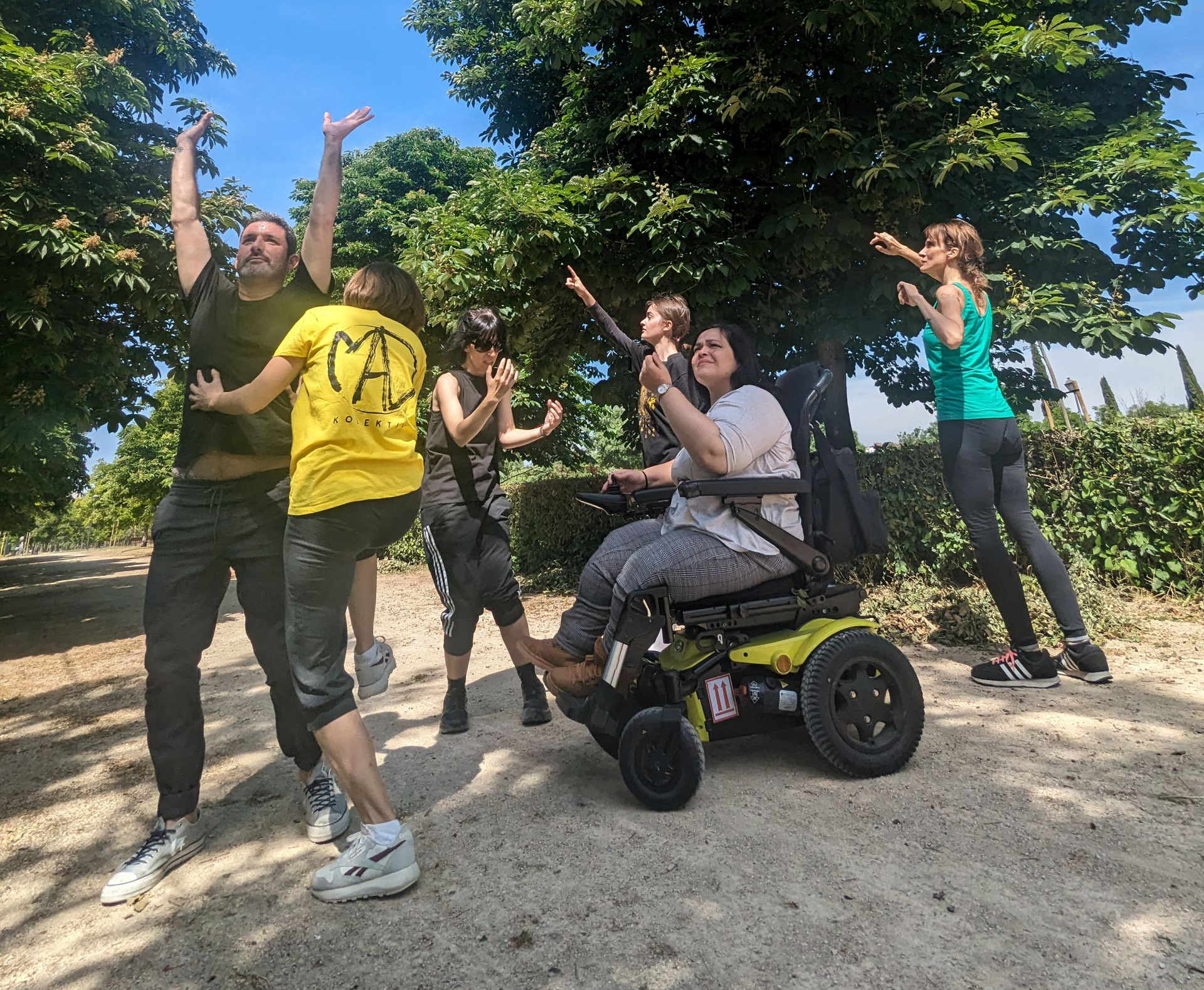 Deaf and hearing dancers, including a wheelchair user, performing together outdoors in an inclusive community dance project supported by micro grants