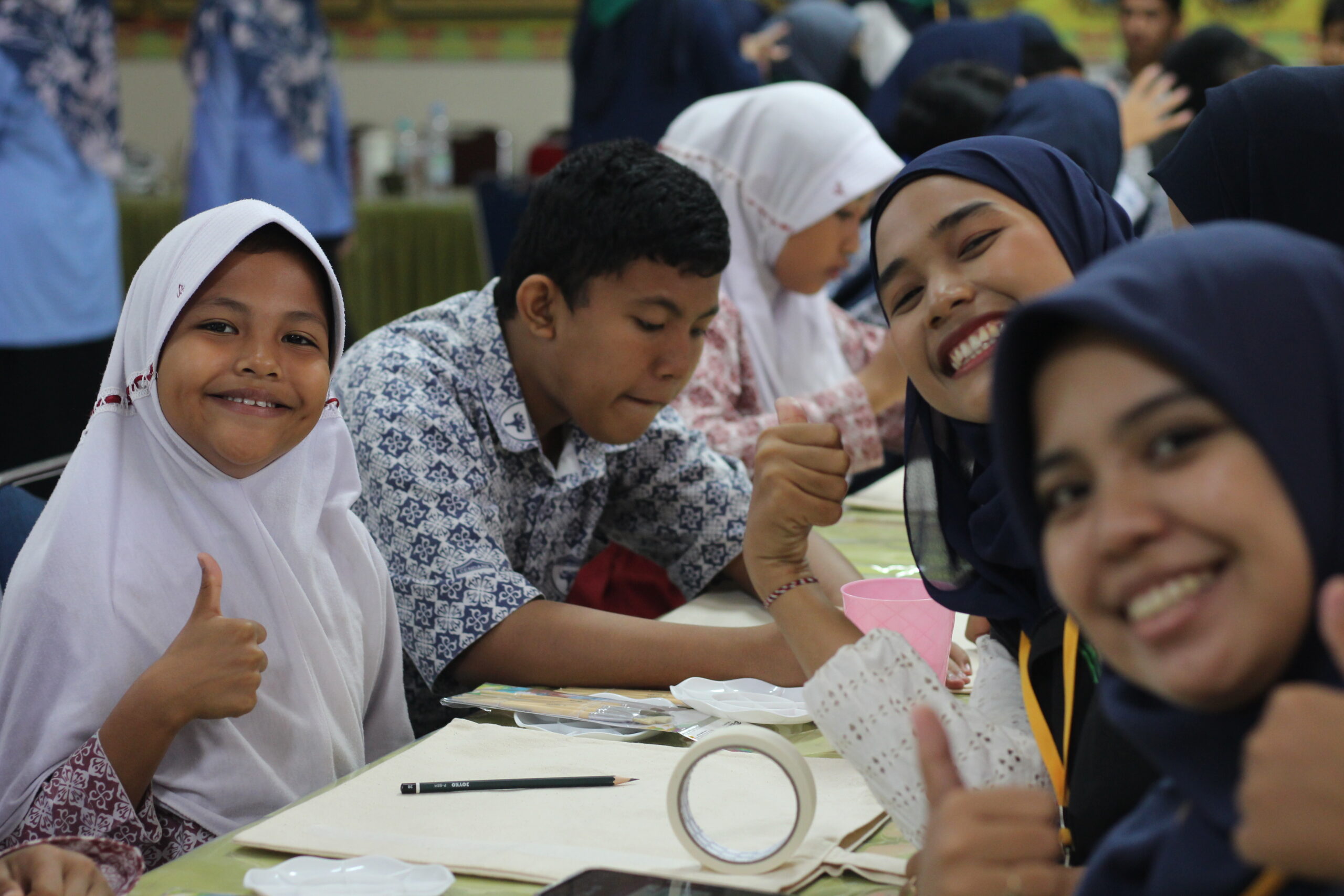 Happy Indonesian children thumb up sign while painting