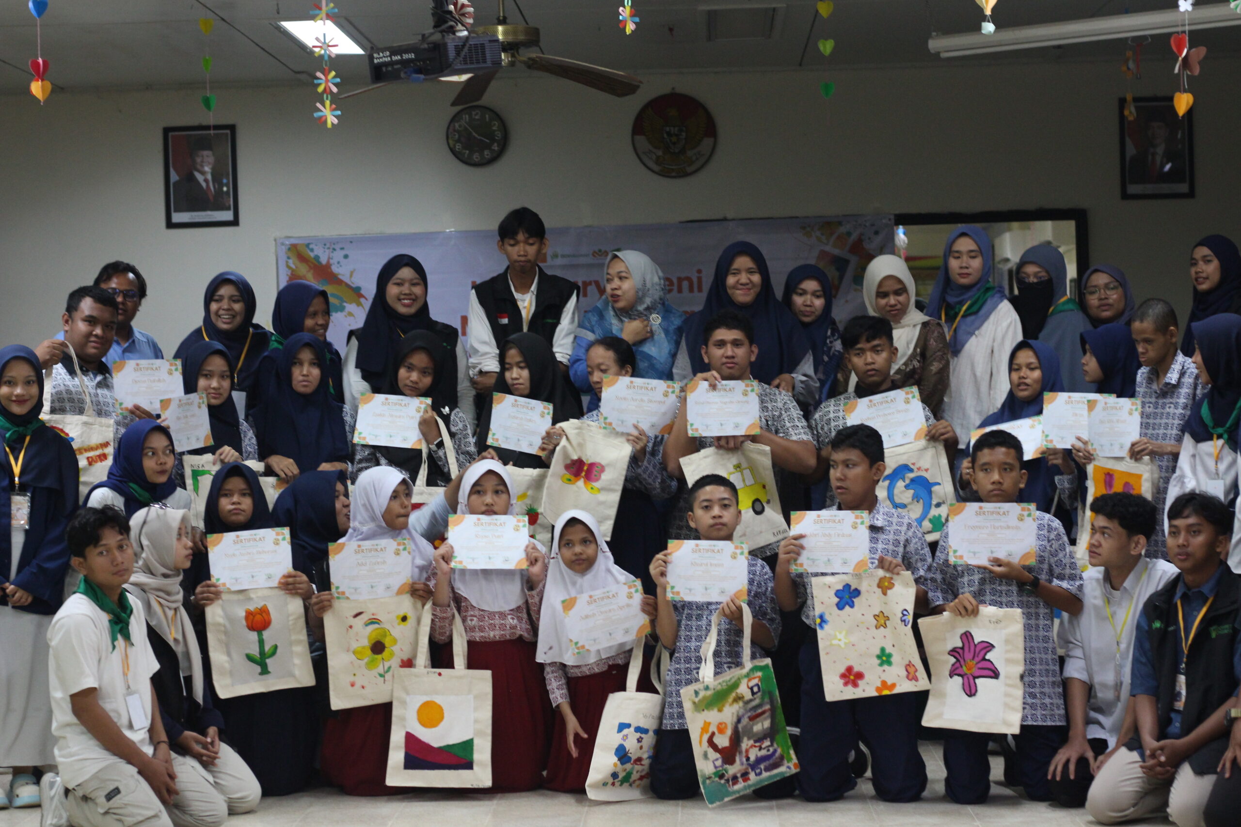 Group photo with all the children and volunteers and the bags painted in the art workshop