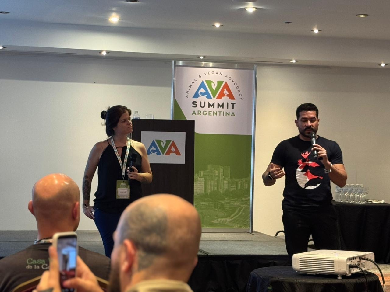 Two young activist, a female and a male, talking on a stage at AVA Conference in Argentina