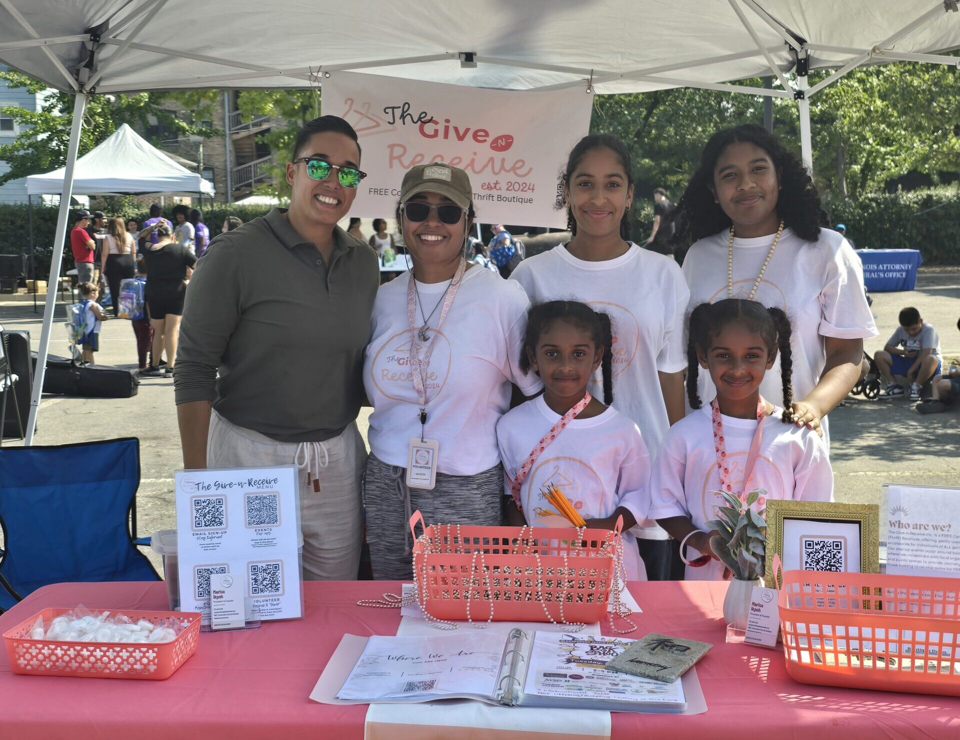An artist in front a mural with arms open