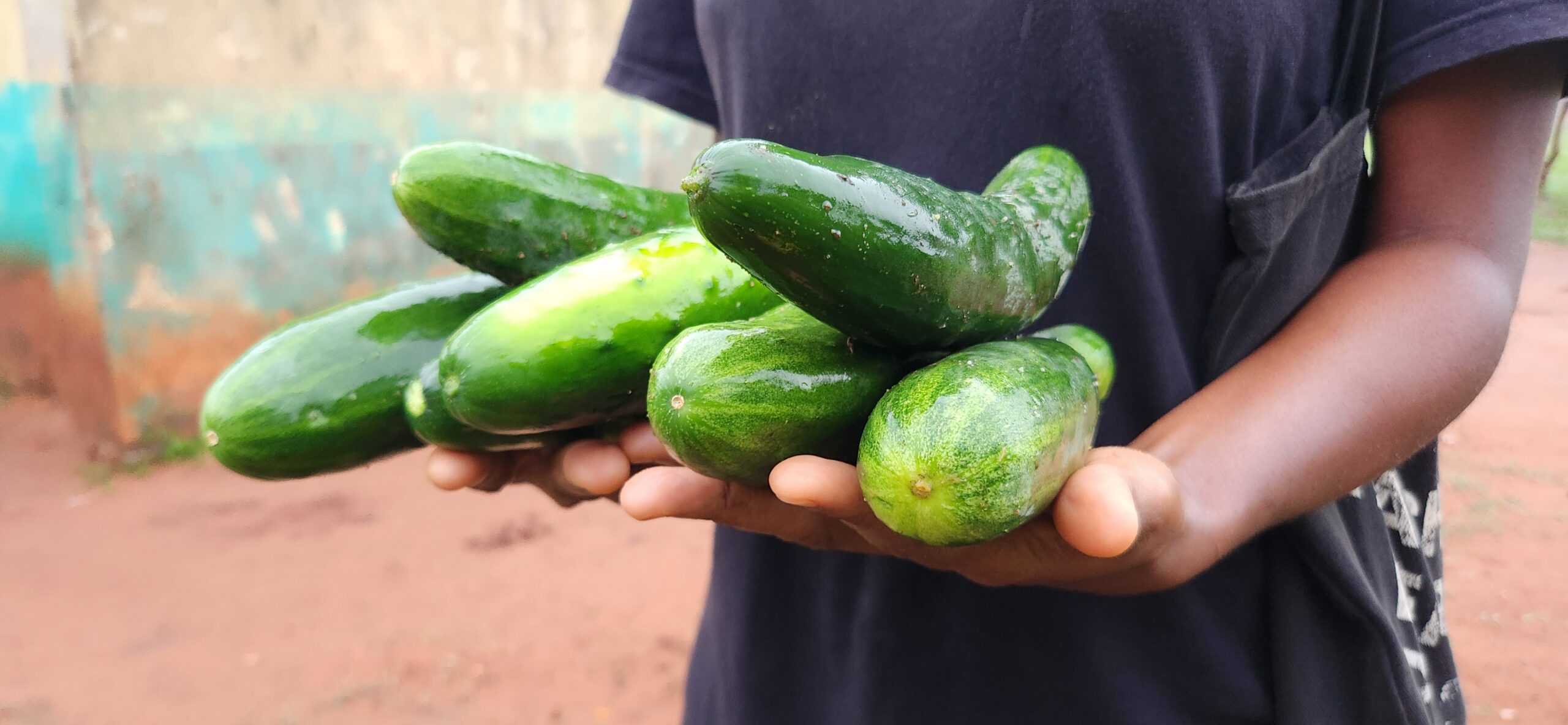 An artist in front a mural with arms open