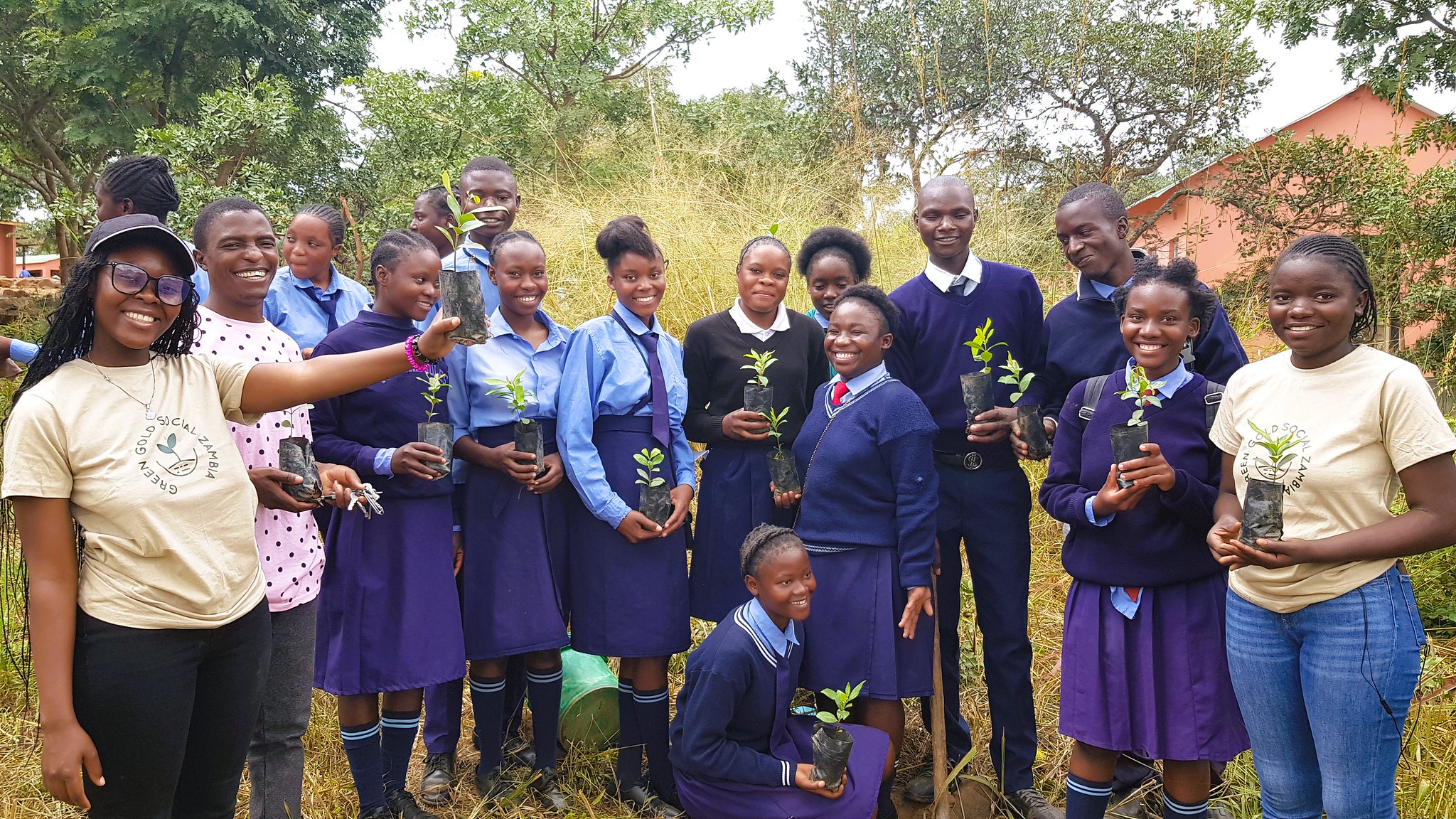 A group of students holding small plants ready to be planted
