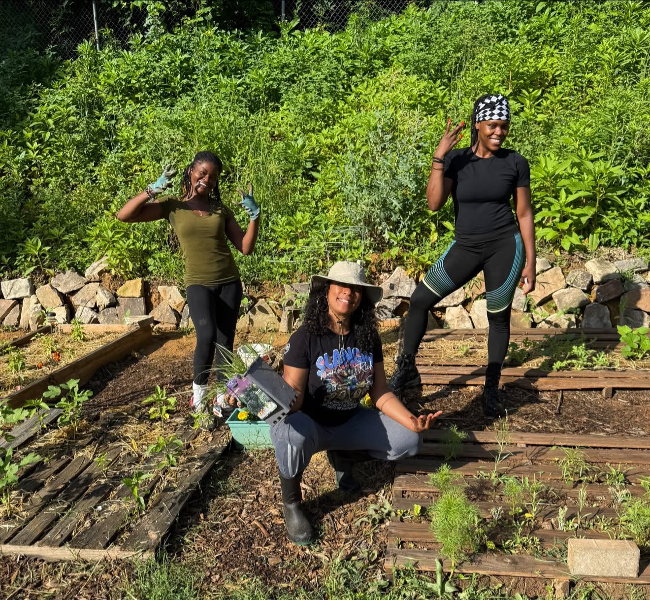 three women working in a vegetable garden and smiling